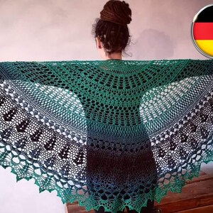 May include: A green and blue crocheted shawl with a lacy design. The shawl is draped over a person's shoulders.