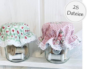 May include: Two glass jars with lids made of fabric with lace trim. The lids are decorated with floral patterns. The jars are filled with spools of thread. The jars are sitting on a white shelf. The text "25 Dateien" is visible in the upper right corner of the image.