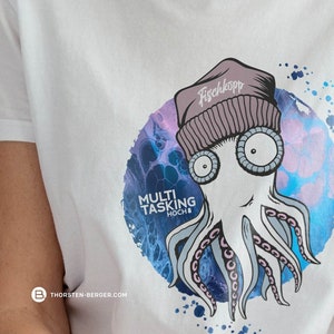 Könnte beinhalten: Weißes T-Shirt mit einem Aufdruck einer Krake, die eine Mütze mit dem Text "Fischkopp" trägt. Die Krake ist von einem wasserfarbenen Design in Blau, Rosa und Lila umgeben. Der Text "MULTI TASKING HOCH 8" ist unter der Krake gedruckt.