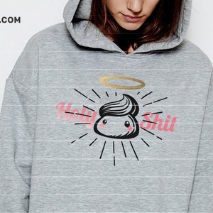 Pode incluir: Um moletom cinza com um gráfico de um cocô de desenho animado com uma auréola e o texto "Holy Shit" em rosa.