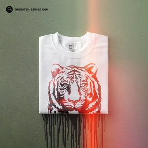 May include: White t-shirt with a black and red tiger print. The tiger's face is centered on the shirt and the print has a dripping effect.