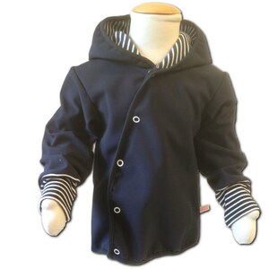 Pode incluir: Uma jaqueta azul marinho com capuz e detalhes em branco listrado na gola e punhos. A jaqueta tem fecho de pressão e um caimento solto.
