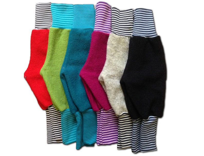 May include: A set of seven pairs of colorful fleece leggings with striped cuffs. The leggings are in red, green, teal, pink, gray, and black.