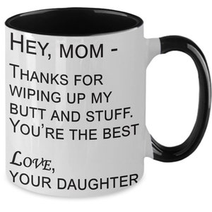 May include: White ceramic mug with a black interior and handle. The mug features the text "HEY, MOM - THANKS FOR WIPING UP MY BUTT AND STUFF. YOU'RE THE BEST LOVE, YOUR DAUGHTER" in black lettering.