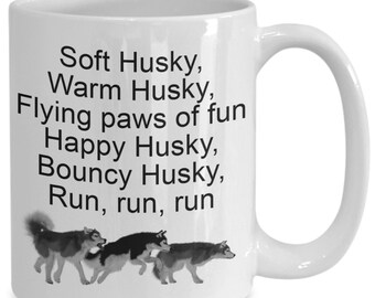May include: White ceramic coffee mug with a black and white illustration of three huskies running. The text on the mug reads: "Soft Husky, Warm Husky, Flying paws of fun Happy Husky, Bouncy Husky, Run, run, run"