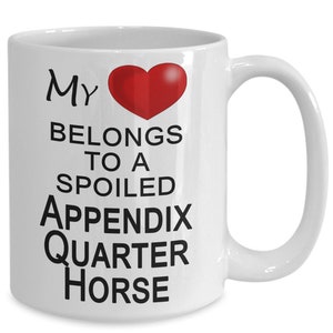 May include: White ceramic coffee mug with a red heart and the text "My heart belongs to a spoiled Appendix Quarter Horse".