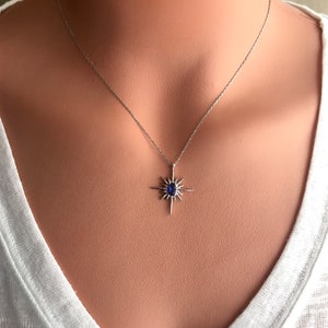 K&ouml;nnte beinhalten: Eine silberne Halskette mit einem blauen Edelstein-Sternenanh&auml;nger.