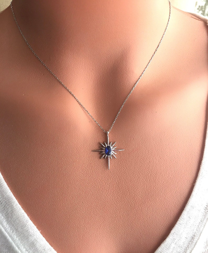 K&ouml;nnte beinhalten: Eine silberne Halskette mit einem blauen Edelstein-Sternenanh&auml;nger.