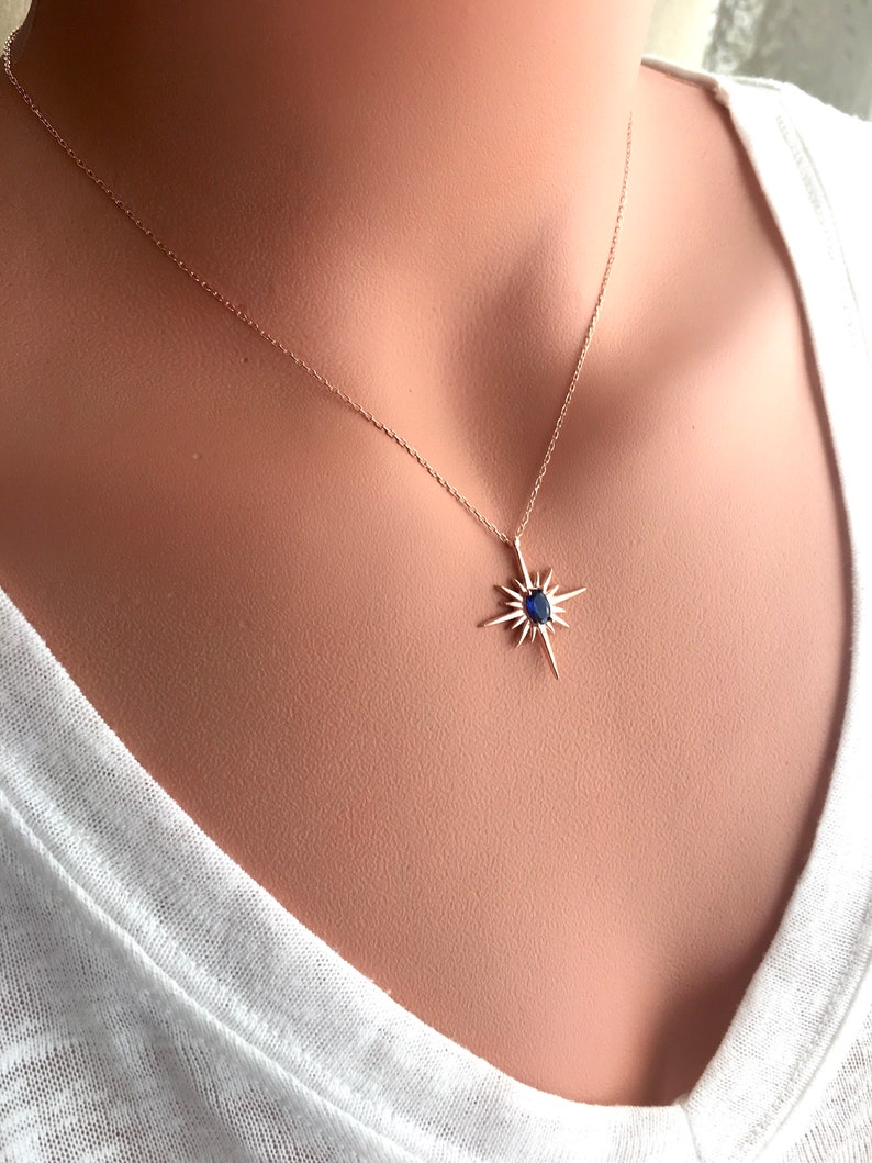 K&ouml;nnte beinhalten: Eine silberne Halskette mit einem blauen Edelstein-Sternenanh&auml;nger.