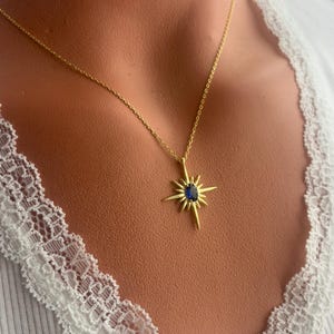 K&ouml;nnte beinhalten: Goldkette mit einem blauen Edelstein-Sternenanh&auml;nger.