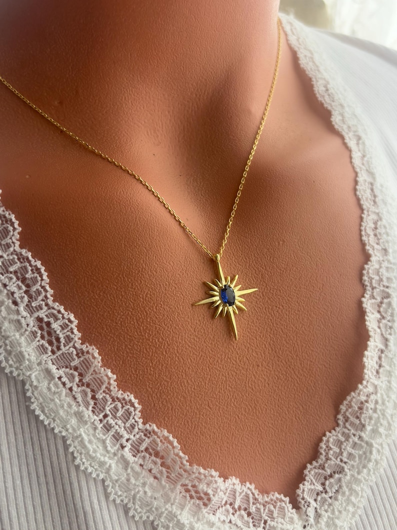 K&ouml;nnte beinhalten: Goldkette mit einem blauen Edelstein-Sternenanh&auml;nger.