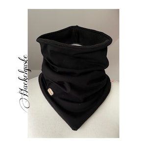 Könnte beinhalten: Schwarzer Fleece-Halswärmer mit dreieckiger Form und einem kleinen Etikett auf der Vorderseite.