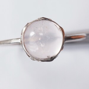 Puede incluir: Un anillo de plata con una piedra redonda de cuarzo rosa p&aacute;lido.