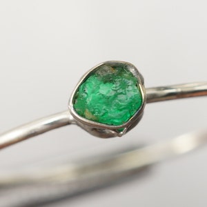 Peut inclure: Une bague en argent avec une &eacute;meraude verte sertie dans un sertissage &agrave;  bezel.