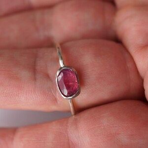 May include: A silver ring with a pink oval gemstone.
