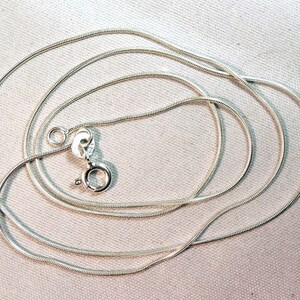 Puede incluir: Un collar de cadena de serpiente de plata con cierre de langosta.