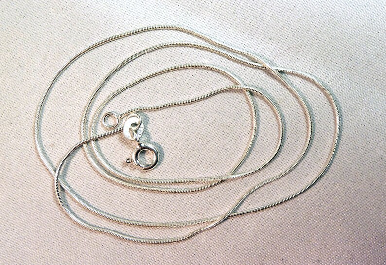 Puede incluir: Un collar de cadena de serpiente de plata con cierre de langosta.