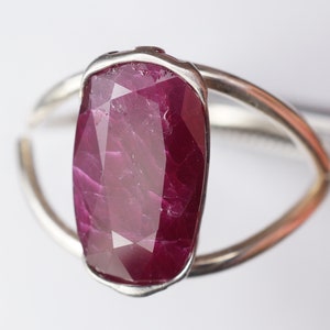 Op de afbeelding: Een zilveren ring met een grote, gefacetteerde, dieprode robijn.