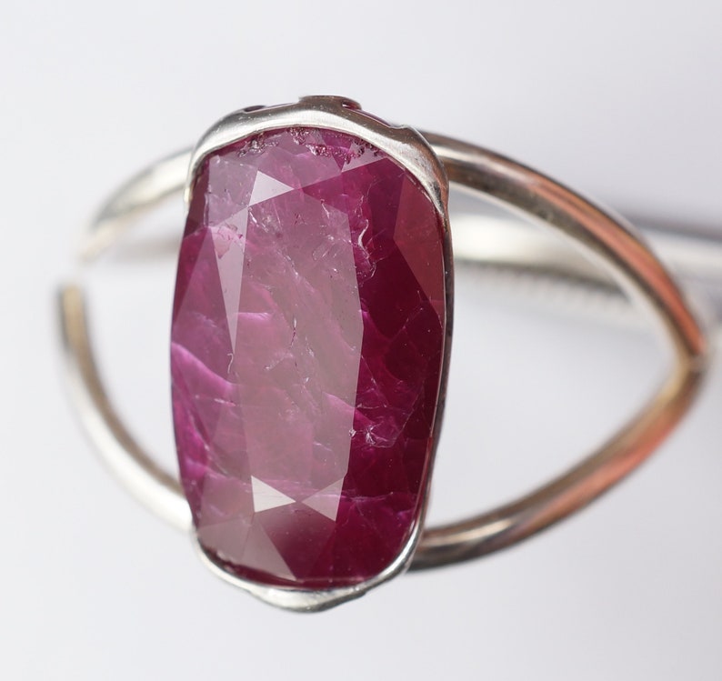 Op de afbeelding: Een zilveren ring met een grote, gefacetteerde, dieprode robijn.