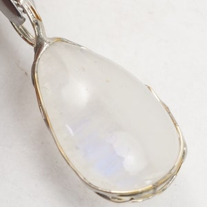May include: A silver pendant with a teardrop-shaped moonstone set in a silver bezel. The moonstone has a milky white color with a hint of blue.