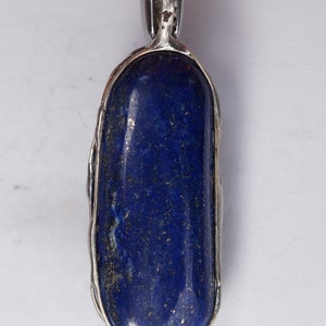 May include: A silver pendant with a deep blue lapis lazuli stone set in a silver bezel.