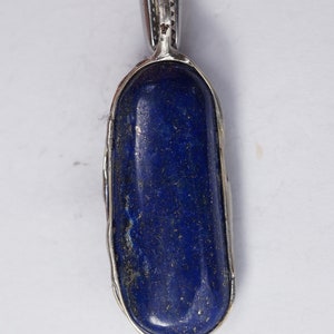 May include: A silver pendant with a deep blue lapis lazuli stone set in a bezel setting.