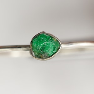Peut inclure: Une bague en argent avec une &eacute;meraude verte. L'&eacute;meraude est une pierre brute et naturelle avec une forme unique.