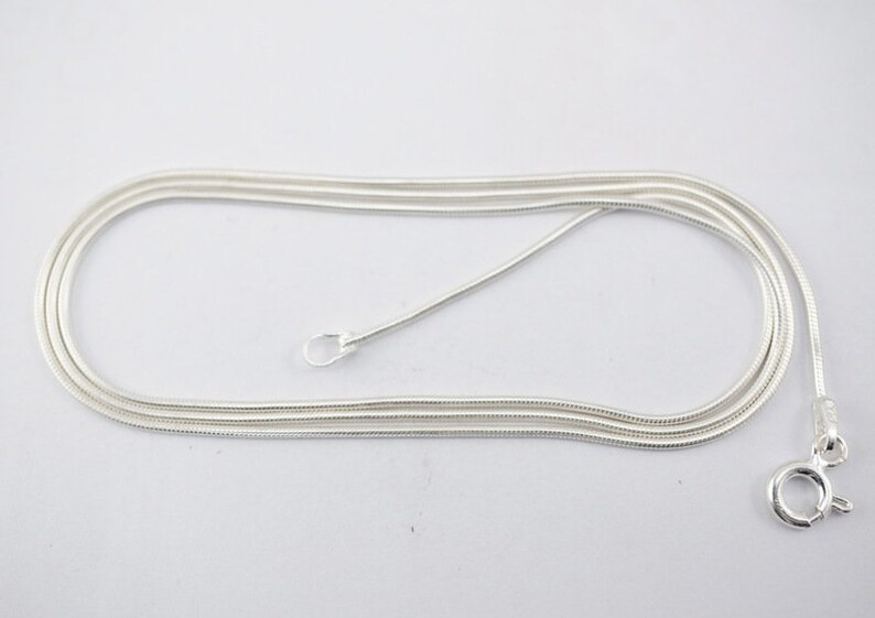 Puede incluir: Un collar de cadena de serpiente de plata con cierre de langosta.