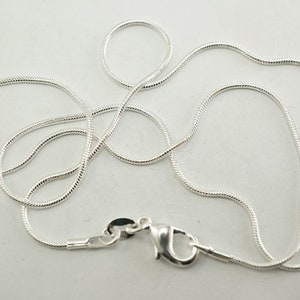 Puede incluir: Un collar de cadena de serpiente de plata con cierre de langosta.