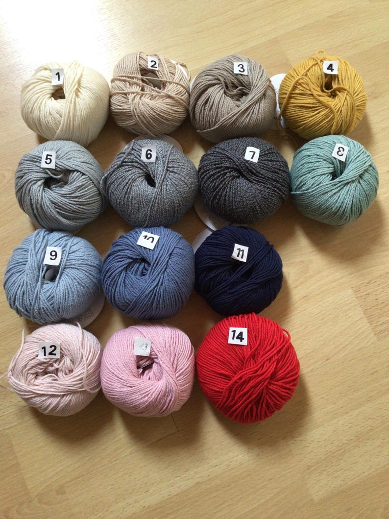 May include: Fourteen balls of yarn in various colors, including white, beige, gray, blue, green, yellow, pink, and red. Each ball is numbered 1 through 14.