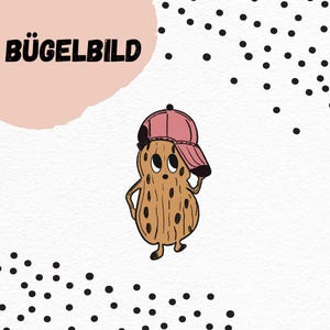 Puede incluir: Un personaje de dibujos animados de cacahuete con una gorra de béisbol rosa, cuerpo marrón y manchas negras. La imagen incluye el texto "BÜGELBILD" en letras negras sobre un fondo rosa, con lunares negros.