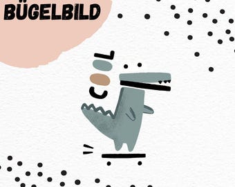 Può includere: Un personaggio di cartone animato di coccodrillo blu che indossa un cappello nero e fa skateboard. La parola "COOL" è scritta in lettere marroni e blu sopra il coccodrillo. Lo sfondo è bianco con pois neri. Il testo "BÜGELBILD" è scritto in nero su uno sfondo rosa.