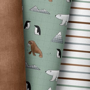Könnte beinhalten: Ein grüner und weißer Stoff mit Illustrationen von Pinguinen, Eisbären, Walrossen und Bergen. Der Stoff ist ein sich wiederholendes Muster.