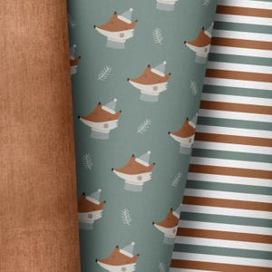 Puede incluir: Un patrón sin costuras que presenta un diseño repetitivo de zorros con gorros de invierno sobre un fondo azul verdoso. Los zorros miran hacia la derecha y tienen detalles blancos en sus caras. El fondo es de un color azul verdoso sólido con pequeñas ramitas blancas dispersas.