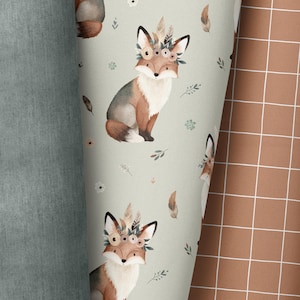 Op de afbeelding: Een naadloos patroon met een herhalend ontwerp van vossen die bloemenkronen dragen. De vossen zijn bruin en wit op een lichtgroene achtergrond. Het patroon is perfect voor stoffen, behang of inpakpapier.