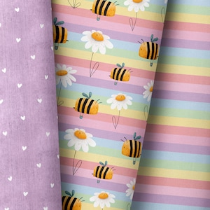 Könnte beinhalten: Ein farbenfroher Stoff mit einem sich wiederholenden Muster aus Bienen und Gänseblümchen. Der Stoff ist gestreift mit abwechselnden Farben von Rosa, Gelb, Grün und Blau. Die Bienen sind gelb und schwarz mit kleinen Flügeln. Die Gänseblümchen sind weiß mit gelben Zentren.