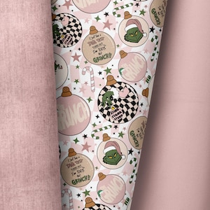 Könnte beinhalten: Rosa-grünes Geschenkpapier mit einem sich wiederholenden Muster aus Weihnachtskugeln. Die Kugeln zeigen den Grinch, Zuckerstangen, Sterne und den Text "Ich habe gerade einen DNA-Test gemacht, es stellt sich heraus, dass ich zu 100 % der Grinch bin!"
