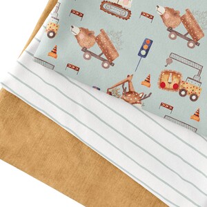 May include: Two pieces of fabric, one with a light blue background and a repeating pattern of animals and construction vehicles, and the other a solid brown fabric.