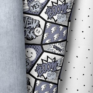 May include: Black and white comic book style fabric with words like "BOOM!" and "NEW YORK" and lightning bolts. The fabric is on a white background with black dots.