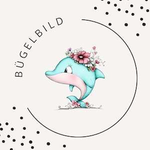 Könnte beinhalten: Eine grafische Illustration eines hellblauen Delfins mit rosa Bauch und einem Kranz aus rosa und weißen Blumen auf dem Kopf. Der Text BÜGELBILD ist links in schwarzen Großbuchstaben innerhalb eines teilweisen schwarzen Kreisrahmens gedruckt.