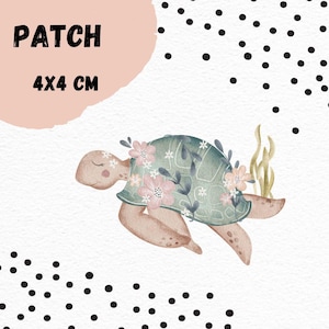 Könnte beinhalten: Eine grüne und braune Schildkröte mit rosa Blüten und grünen Blättern auf ihrem Panzer. Die Schildkröte schwimmt im Wasser. Das Bild ist ein 4x4 cm großes Patch.