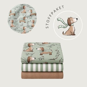 May include: A stack of three folded fabrics. The top fabric is light green with a repeating pattern of brown dachshunds wearing green and white striped scarves and small leaves. The middle fabric has green and white stripes. The bottom is solid brown.
