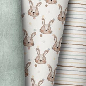 May include: A white background with a repeating pattern of brown bunnies with white accents. The bunnies have brown eyes and noses and are surrounded by small, colourful dots.