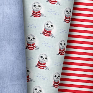 Könnte beinhalten: Eine Rolle hellblauen Denim-Stoffs neben zwei gemusterten Stoffen. Ein Stoff zeigt Robben mit rot-weiß gestreiften Hemden auf hellblauem Hintergrund. Der andere Stoff hat rot-weiße horizontale Streifen.