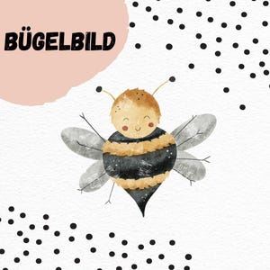 May include: A cute cartoon bee with black and yellow stripes and a smiling face. The bee is on a white background with black polka dots. The text "BÜGELBILD" is in the upper left corner of the image.