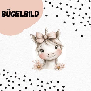Puede incluir: Ilustración caprichosa de un unicornio con un lazo rosa y flores. El unicornio tiene pelaje blanco, un cuerno en espiral y mejillas rosadas. El texto "BÜGELBILD" está en letras negras sobre un fondo rosa.
