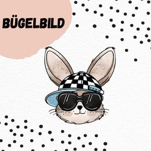 Può includere: Uno sfondo bianco con pois neri. Un coniglio dei cartoni animati che indossa un cappello a scacchi bianco e nero con una visiera blu e occhiali da sole. Il testo "BÜGELBILD" è nell'angolo in alto a sinistra dell'immagine.
