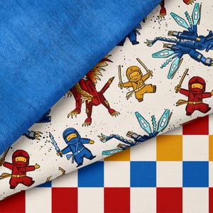 Puede incluir: Imagen en capas con tres patrones de tela distintos. La capa superior es de tela azul lisa. Debajo, una tela color crema muestra un estampado de ninjas y dragones. La capa inferior es un patrón de cuadros rojos, blancos, azules y amarillos.