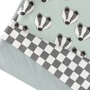 Könnte beinhalten: Drei Stoffmuster, eines mit einem karierten Muster in Schwarz und Weiß, eines mit einem hellgrünen Hintergrund und einem sich wiederholenden Muster von Dachsgesichtern und eines mit einem hellgrünen strukturierten Muster.