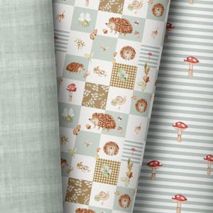 Può includere: Sono presentati tre diversi modelli di tessuto. Uno è verde chiaro unito, il secondo è un design patchwork con ricci, funghi e ghiande, e il terzo è un motivo a righe con funghi a cappello rosso.